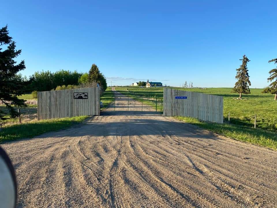 An automatic solar gate at the end of a long farm driveway, providing security and convenience.